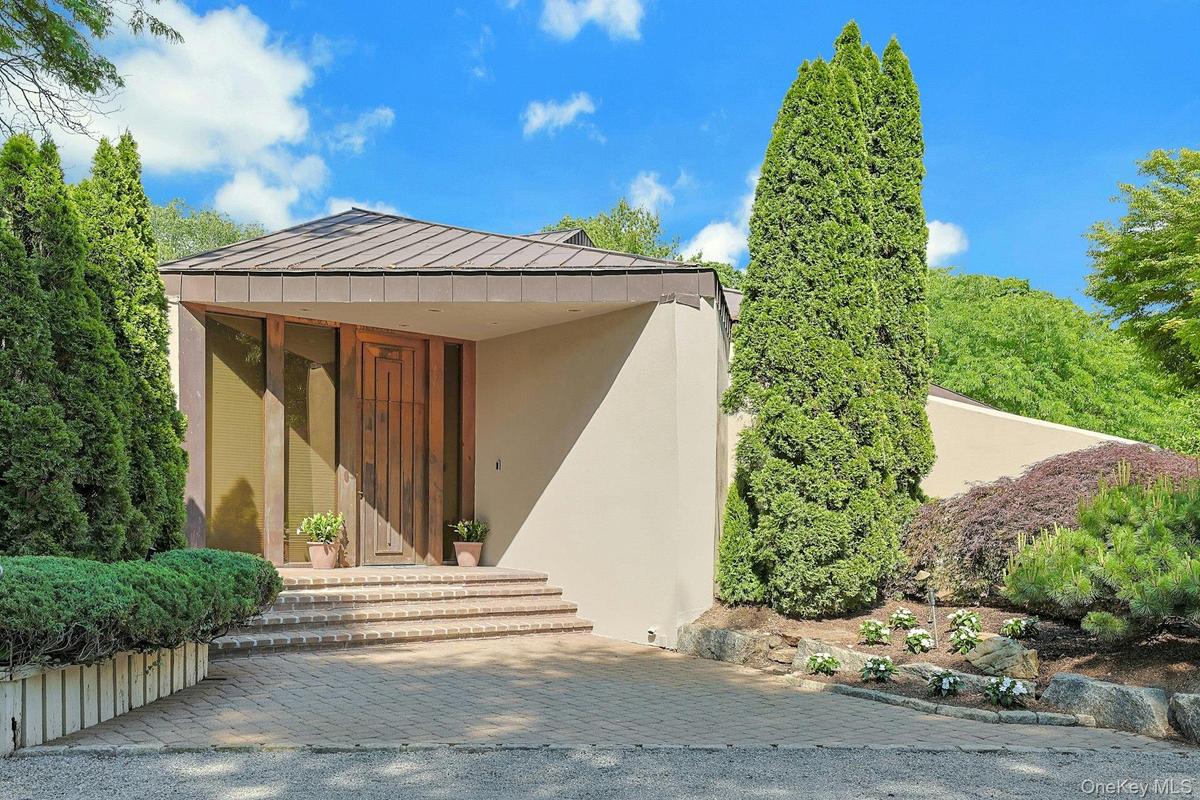 A dramatic copper entry door and striking architectural lines create a memorable first impression upon arrival.