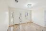 Entryway featuring a white paneled door with decorative sidelights, a tiered crystal chandelier, light-toned tiled flooring with dark accent tiles