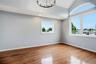 Bedroom featuring vaulted ceilings with an arched window, hardwood flooring, and recessed lighting
