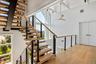 Second Level Stairway featuring a towering ceiling, wood floors