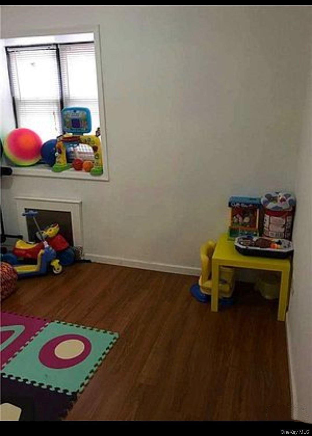 Game room with baseboards and dark wood-style floors