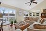 Living area with high vaulted ceiling, wood finished floors, ceiling fan, recessed lighting, and a chandelier