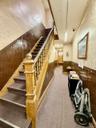 Stairs featuring a wainscoted wall, wallpapered walls, carpet, and wood walls