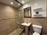 Bathroom featuring walk in shower, tile walls, and recessed lighting