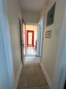 Corridor with light tile patterned floors and electric panel
