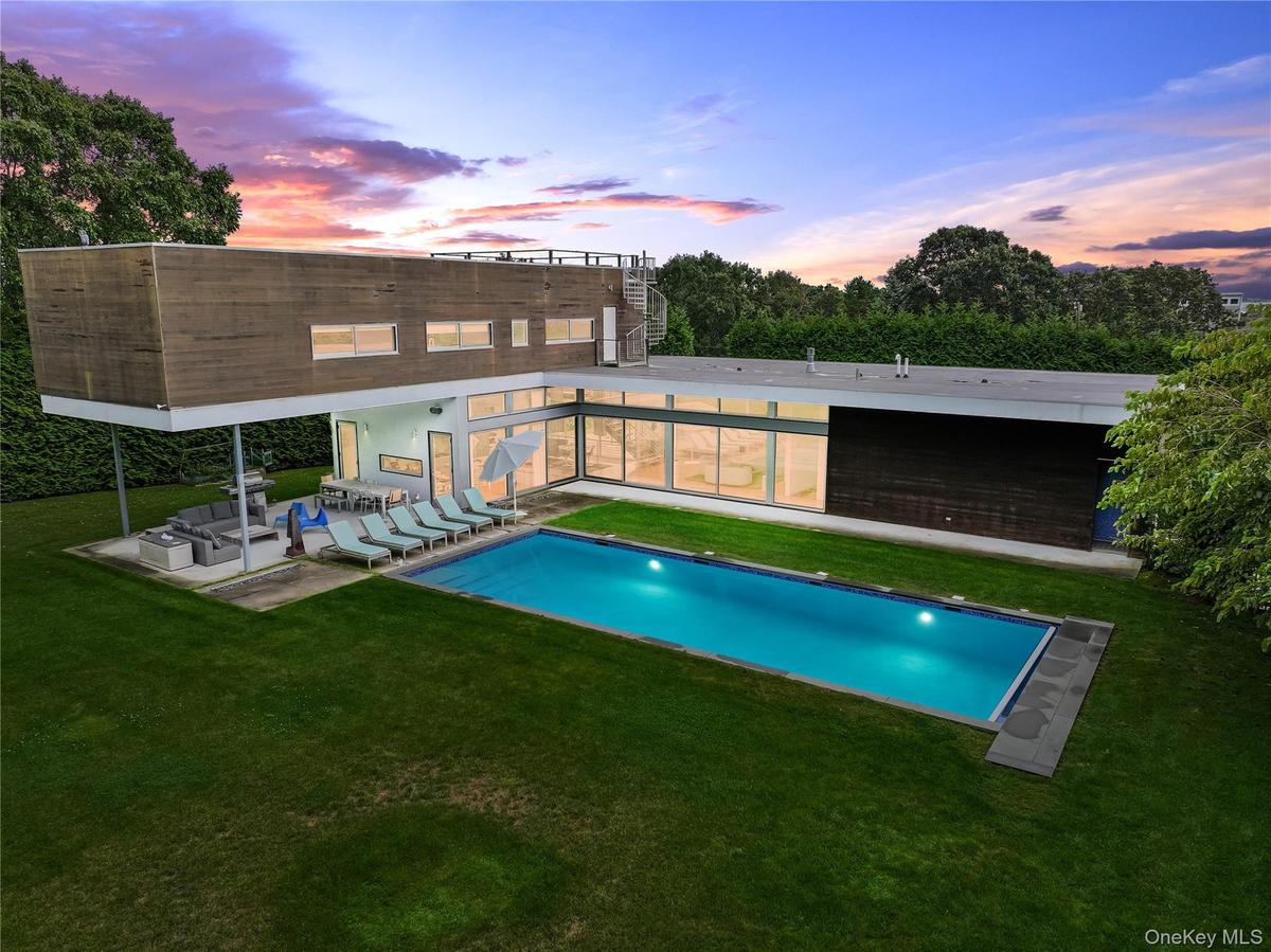 Pool at dusk with a lawn, an outdoor hangout area, an outdoor pool, and a patio area