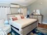 Bedroom featuring dark wood-style floors, baseboards, and a wall unit AC