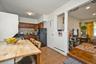 Kitchen featuring baseboard heating, freestanding refrigerator, backsplash, dark countertops, and brown cabinets