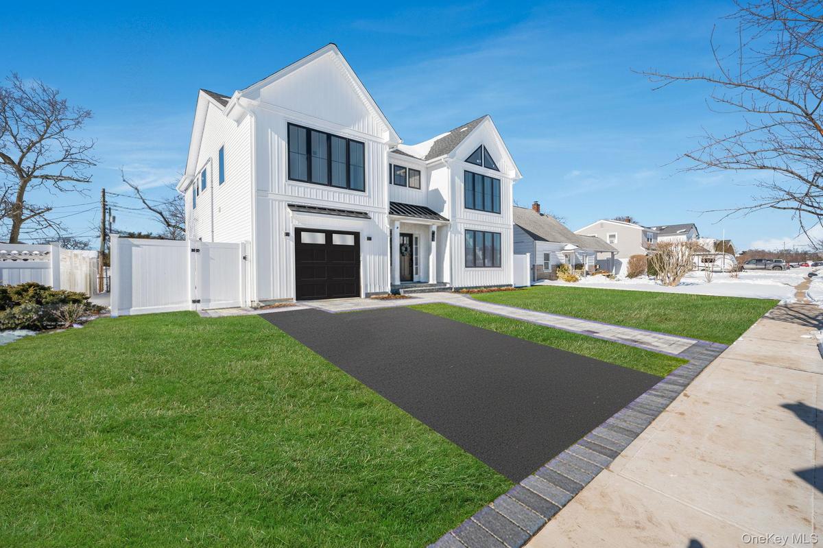 Modern Colonial exterior with board and batten style siding, black framed windows, and a covered entry that creates a strong, custom curb appeal.