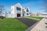 Modern Colonial exterior with board and batten style siding, black framed windows, and a covered entry that creates a strong, custom curb appeal.