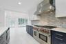 Designed for both serious cooking and effortless entertaining, the kitchen opens directly to the expansive family room, where French doors invite you