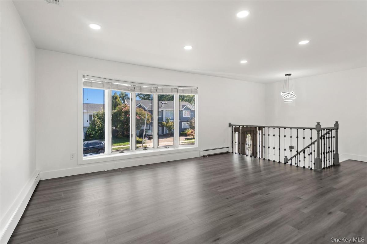 Living Room & Foyer with recessed lighting, a baseboard radiator, and dark wood finished floors