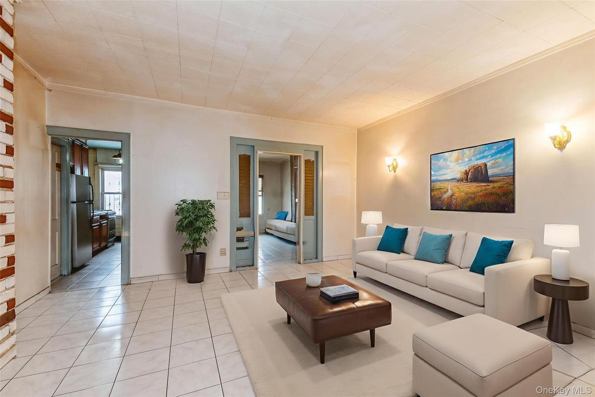 Living room featuring light tile patterned floors and crown molding