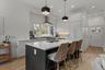 Kitchen with a kitchen bar, a kitchen island with sink, pendant lighting, modern cabinets, and light wood-type flooring