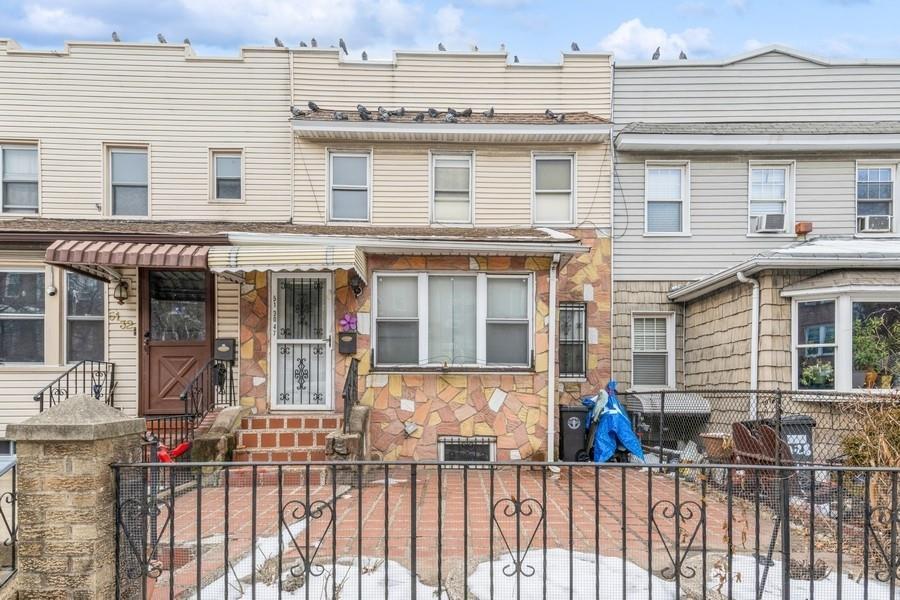 Multi unit property with stone siding, a fenced front yard, and cooling unit