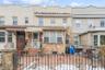Multi unit property with stone siding, a fenced front yard, and cooling unit