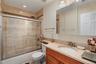 Full bathroom featuring enclosed tub / shower combo, toilet, vanity, and visible vents