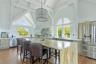 Kitchen with stainless steel appliances, high vaulted ceiling, dark wood finished floors, beam ceiling, and light stone counters
