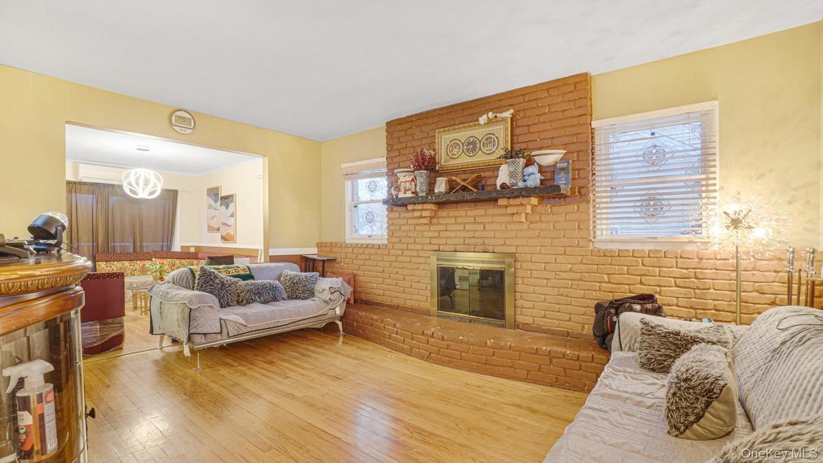 Living room with hardwood / wood-style flooring and a brick fireplace