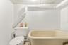 Full bathroom featuring toilet, a freestanding tub, and a paneled ceiling