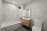 Bathroom with tile walls, vanity, recessed lighting, and a combined bath / shower with marble appearance
