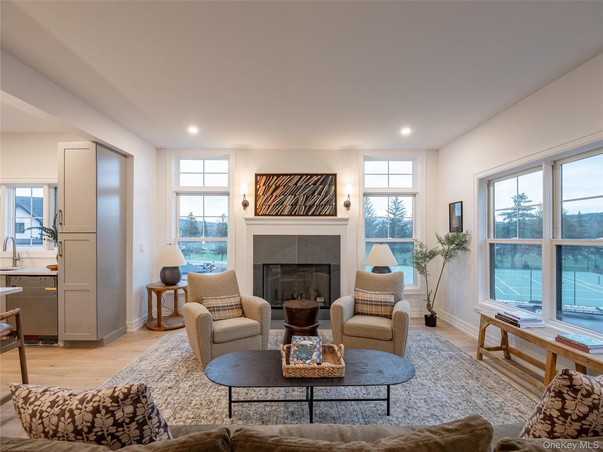 Living area featuring light wood-type flooring, healthy amount of natural light, a fireplace, and recessed lighting