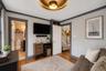 Interior space featuring dark wood-finish flooring, light grey walls with contrasting dark trim, and multiple windows providing natural illumination