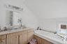 Full bathroom with lofted ceiling, vanity, and a bath