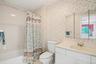 Ensuite primary bathroom with tub & triple mirrored vanity