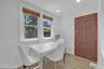 Dining area with light wood-finish flooring, white walls, and recessed lighting