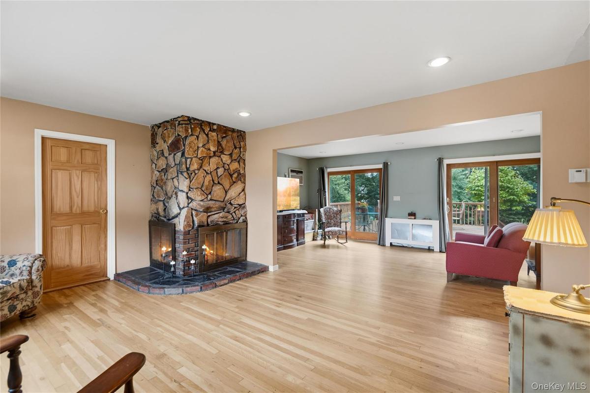 Living Room with Woodburning Fireplace and Entry into Room for Office-Playroom-Gym-4th Bedroom