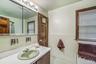 Bathroom featuring vanity, wainscoting, radiator, tile walls, and tile patterned floors