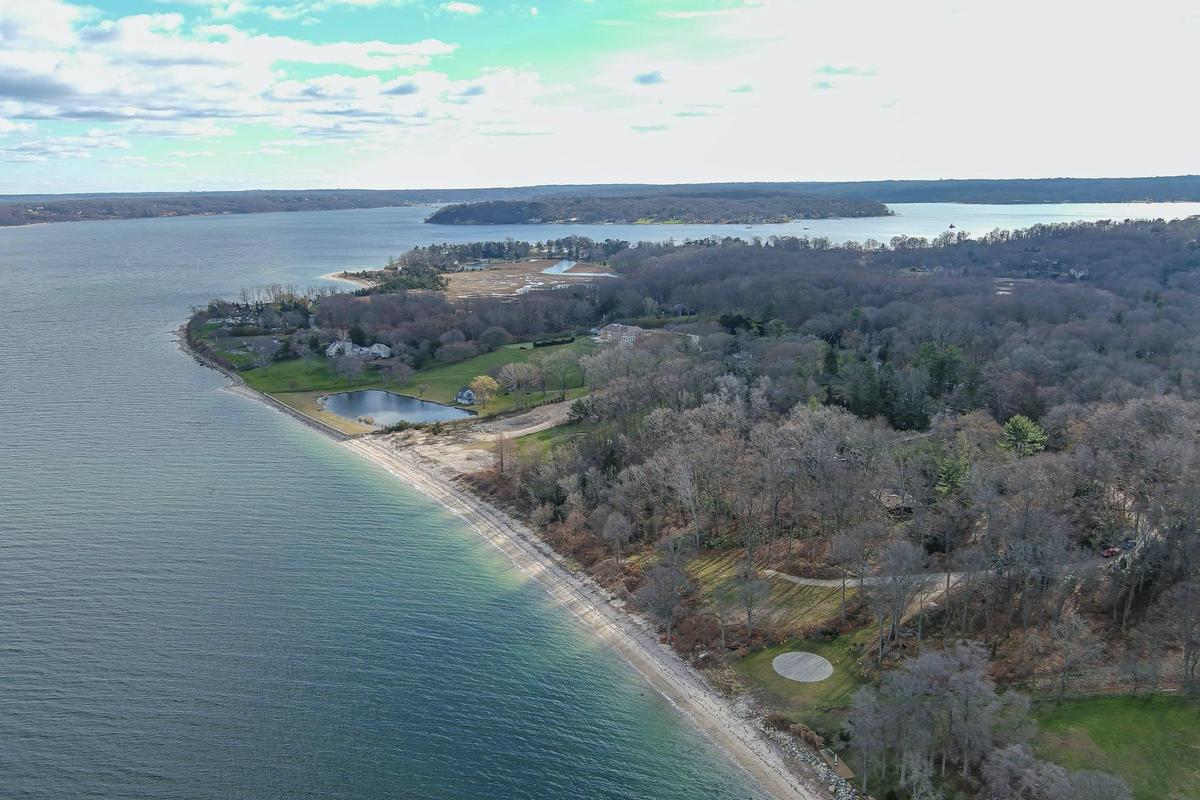 Aerial overview of property's location featuring a nearby body of water and a heavily wooded area