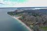 Aerial overview of property's location featuring a nearby body of water and a heavily wooded area