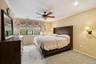 Carpeted room featuring multiple windows with blinds, a ceiling fan, recessed lighting, and wall sconces