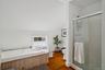 Bathroom featuring a stall shower, hardwood / wood-style flooring, a bath, and lofted ceiling