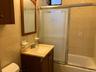 Full bathroom featuring vanity, tile walls, and shower / bath combination with glass door