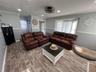 Recessed lighting, wood-finish flooring, two-tone wall paint, crown molding, and a bay window