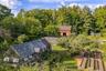 Greenhouse surrounded by medicinal and edible gardens, raised beds, and the historic Cairo Barn beyond