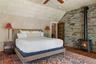 Vaulted ceiling, exposed stone wall, wood stove and adjoining private study
