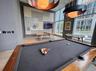 Game room featuring billiards table, floor to ceiling windows, and a towering ceiling