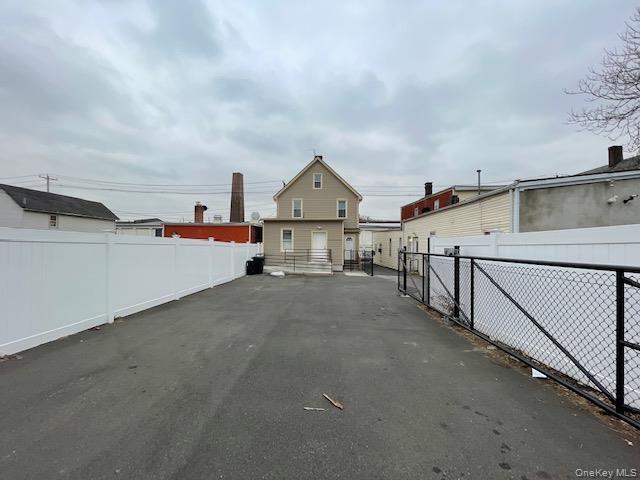 View of asphalt driveway featuring a gated entry