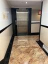 Hall featuring tile walls, elevator, a baseboard radiator, recessed lighting, and crown molding