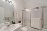 Bathroom with vanity, enclosed tub / shower combo, and lofted ceiling