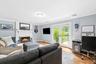 Living area with light wood-style flooring, crown molding, access to the backyard, and a gas fireplace