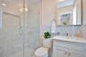 Bathroom featuring vanity, a shower stall, tile walls, and tasteful backsplash