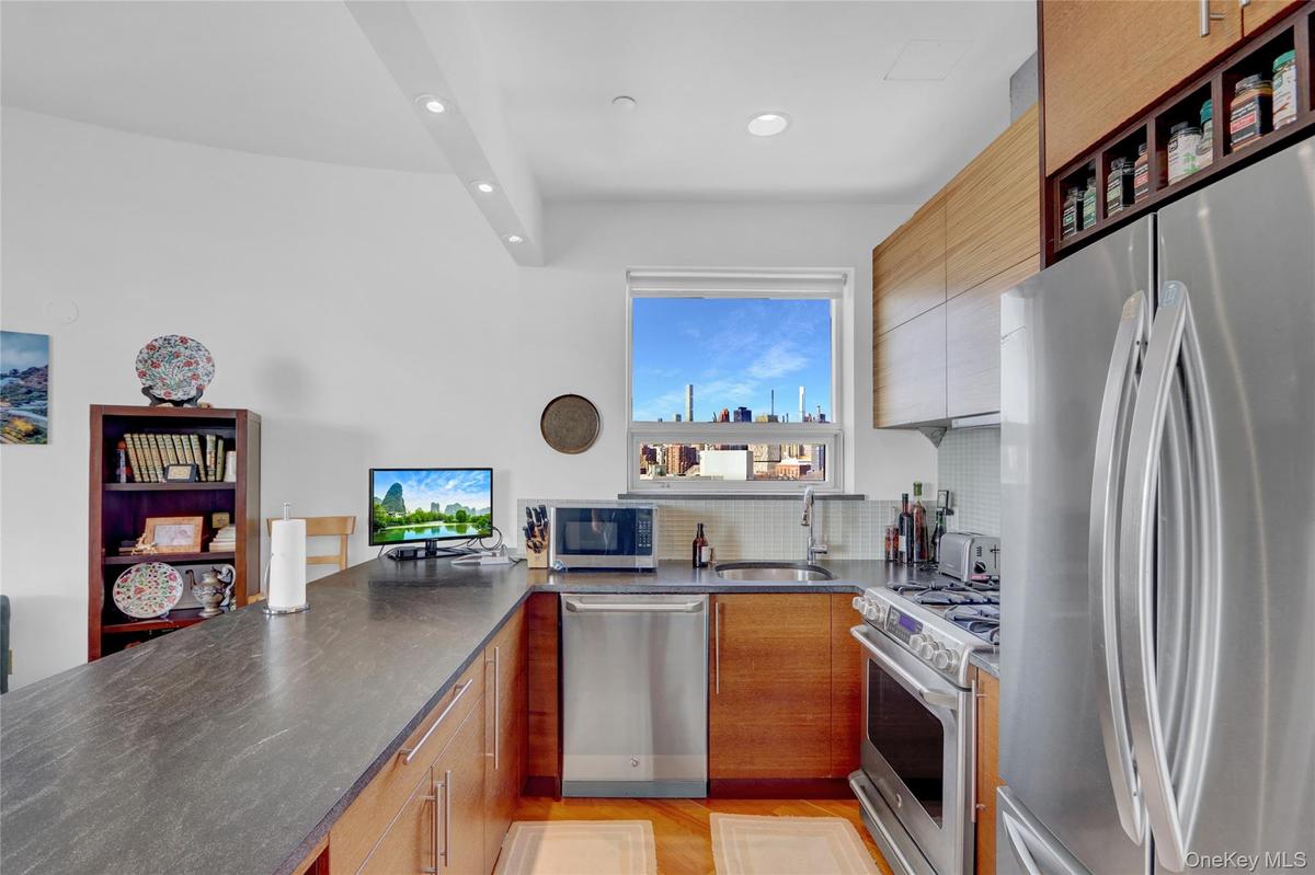 Kitchen with stainless steel appliances, a peninsula, tasteful backsplash, recessed lighting, and open shelves