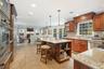 Kitchen with a breakfast bar, open shelves, open floor plan, light stone countertops, and a warming drawer