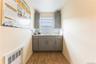 Washroom with light wood-style flooring and radiator