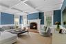Living area featuring wainscoting, coffered ceiling, beamed ceiling, wood finished floors, and a fireplace